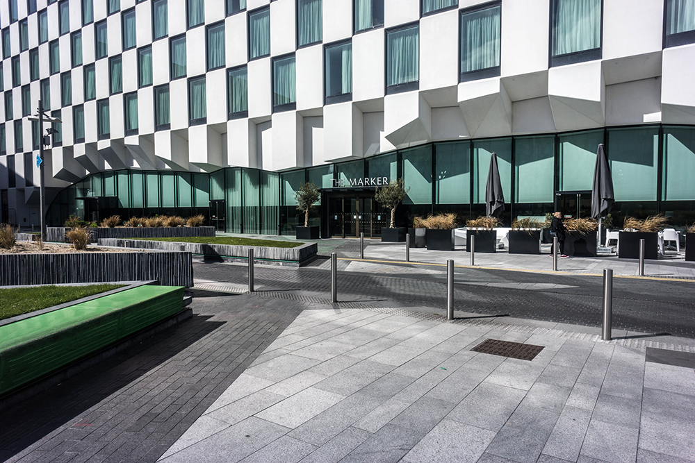 The facade of The Marker Hotel with a concrete footpath and green area to the side