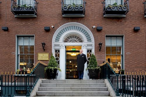 Concierge standing on hotel steps