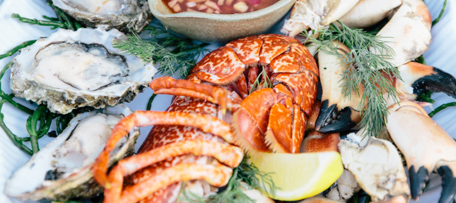 Arrangement of seafood including lobster, oysters crab claws and a slice of lemon