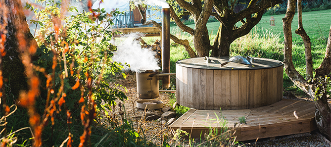 Wooden hot tub set amongst the trees, at Rock Farm Slane.