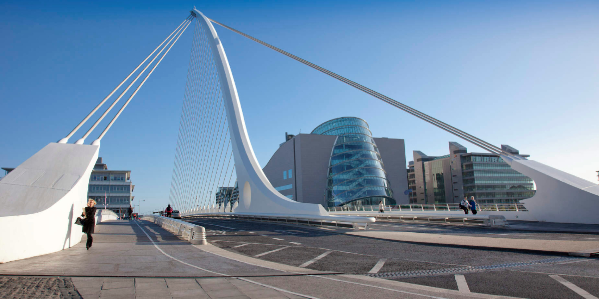 View across a white bridge with buildings and a clear blue sky in the background