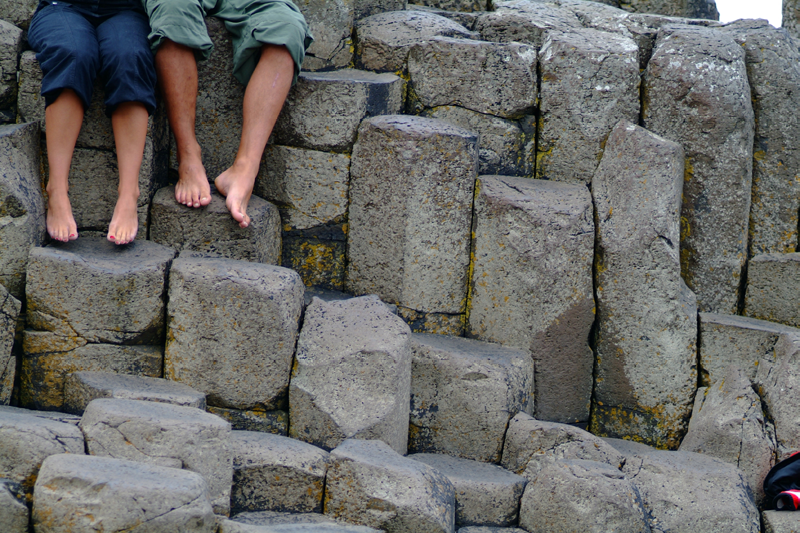 Feet dangling over Giant's Causeway 