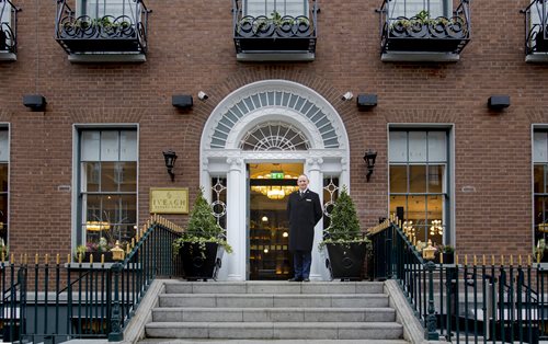 Concierge standing on steps of hotel