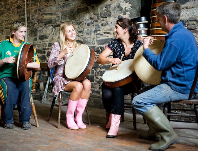 A group learn to play traditional Irish music on the Bodhran.