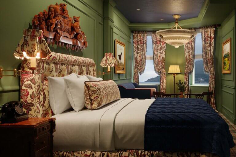 A luxurious, richly decorated room with floral patterns, dark wood accents and a grand view through the windows