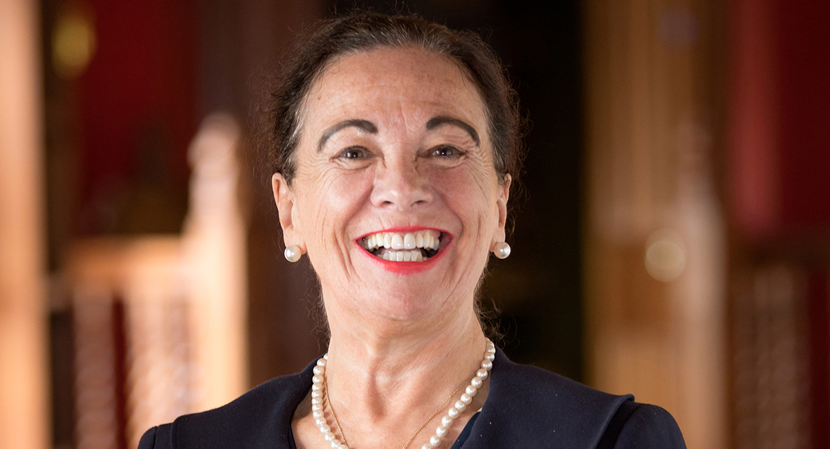 Image of a woman smiling in front of a blurred background