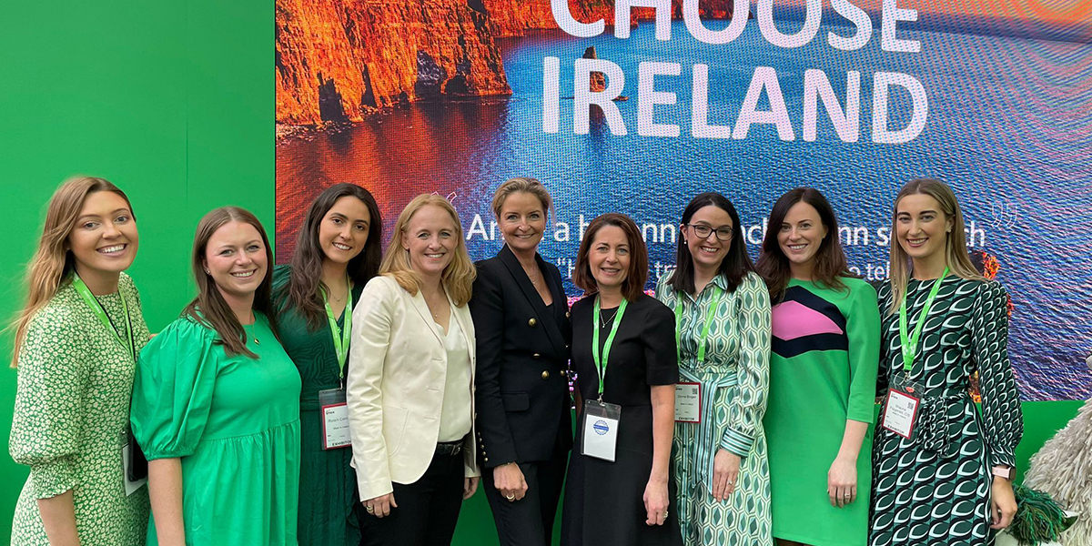 Group of businesswomen smiling and standing in front of a screen that reads, "Choose Ireland."