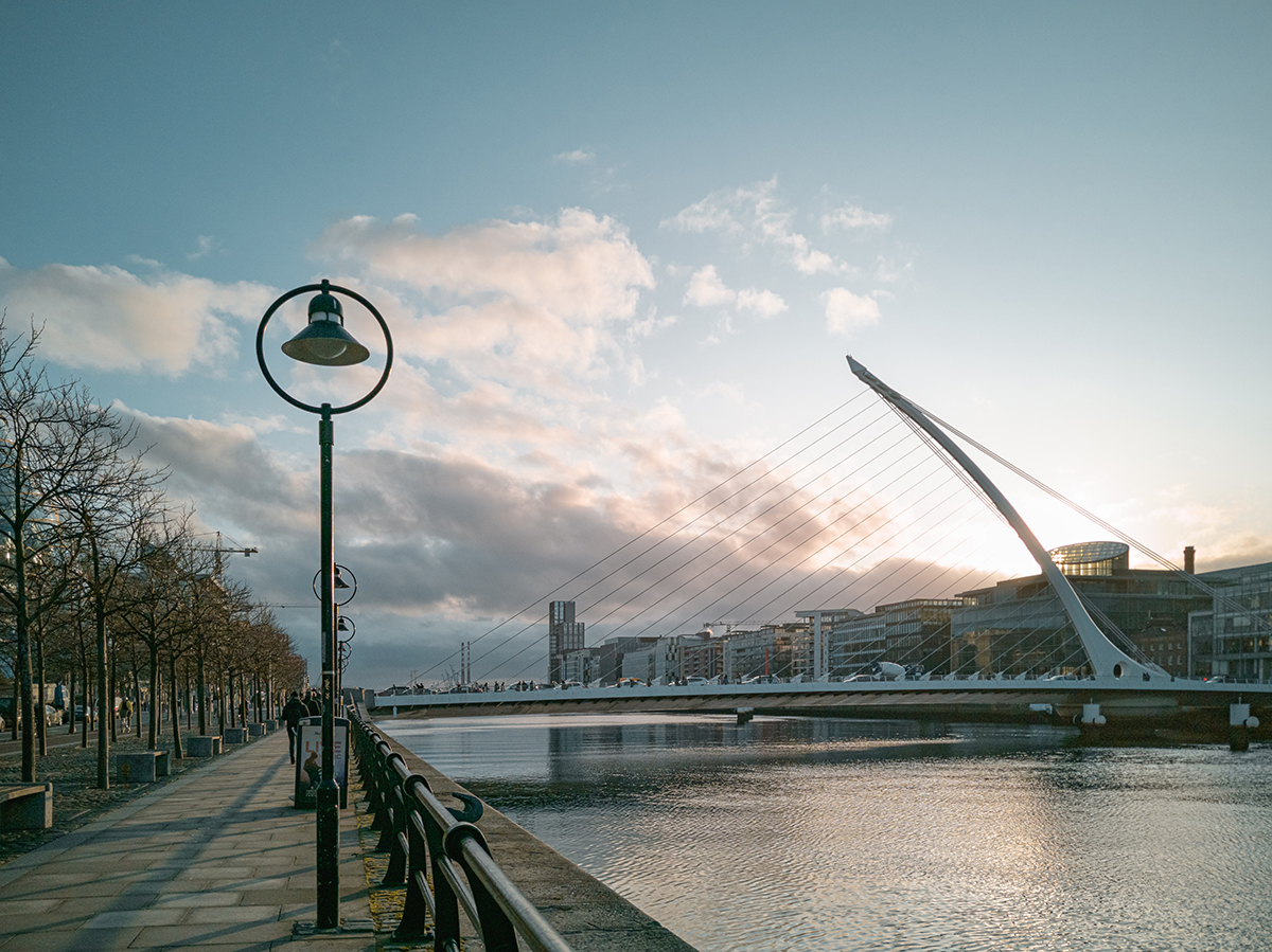 A view of Dublin's Liffey river with the Samuel Beckett bridge (which resembles a harp) in the background