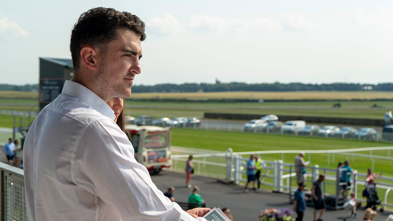 a man is watching the races at the curragh racecourse