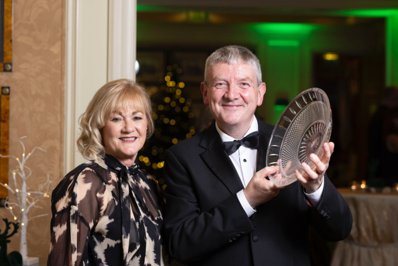 Failte Ireland's Ruth Andrews and Professor Peter McHugh holding a glass award in a function room at the conference ambassador recognition awards