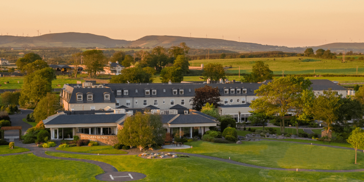 Ballygarry Estate surrounded by lush green fields and rolling hills at sunset, an eco-friendly conference and events venue.
