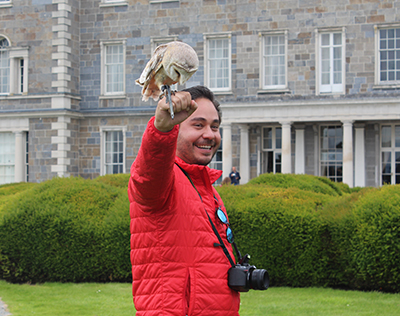 A delegate plays with an owl outside Carton House Hotel