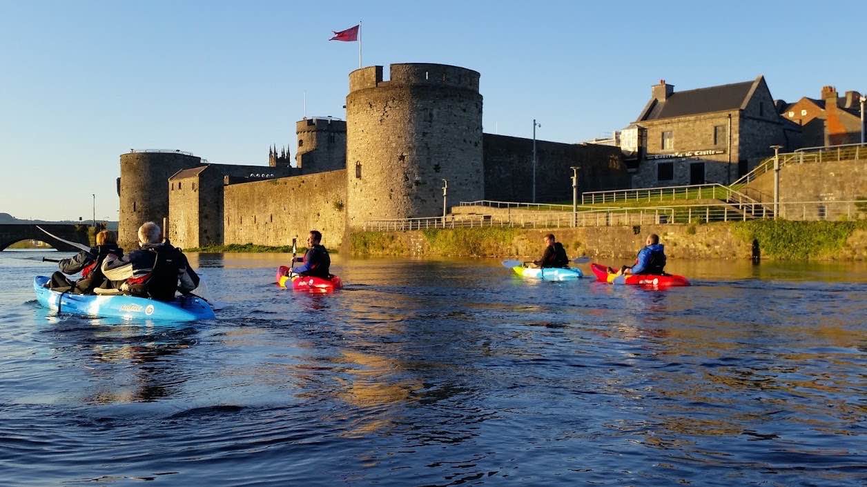 Kayakers in a river with a castle in the background