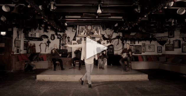 Irish dancer performing with musicians in the background