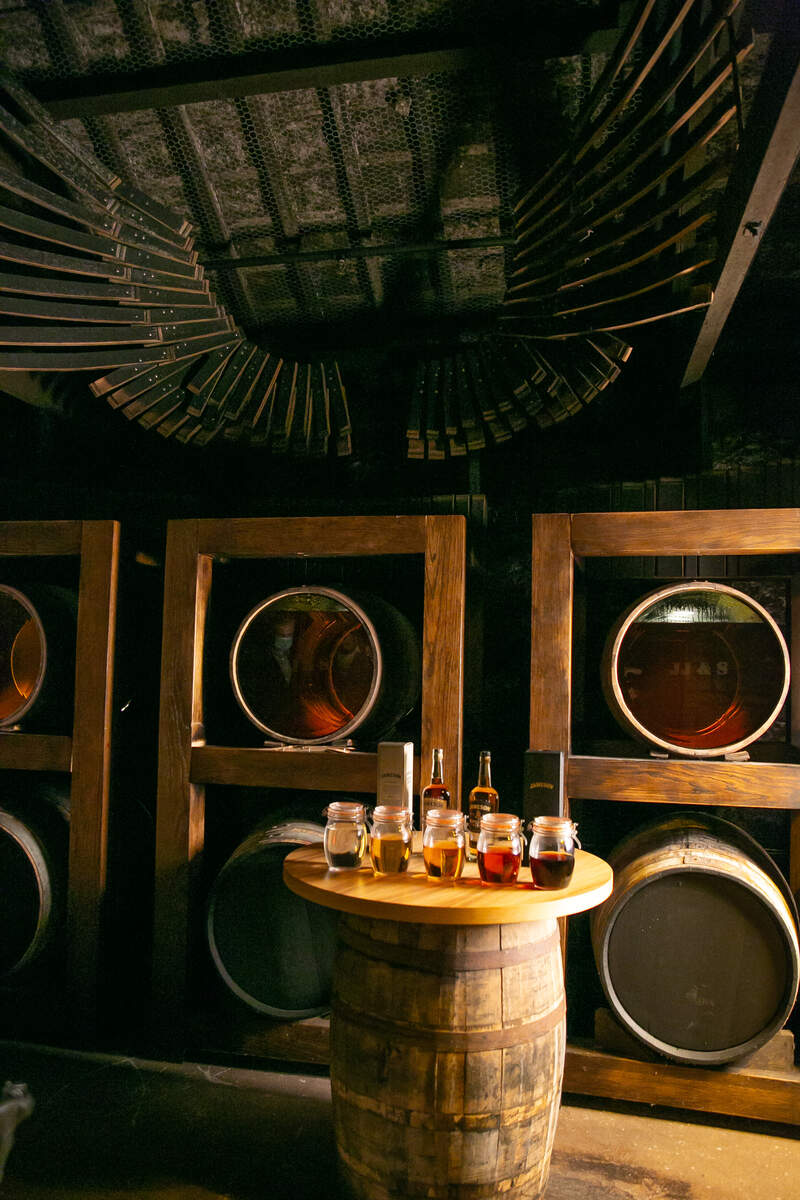 A whiskey barrel topped with a selection of glasses of whiskey